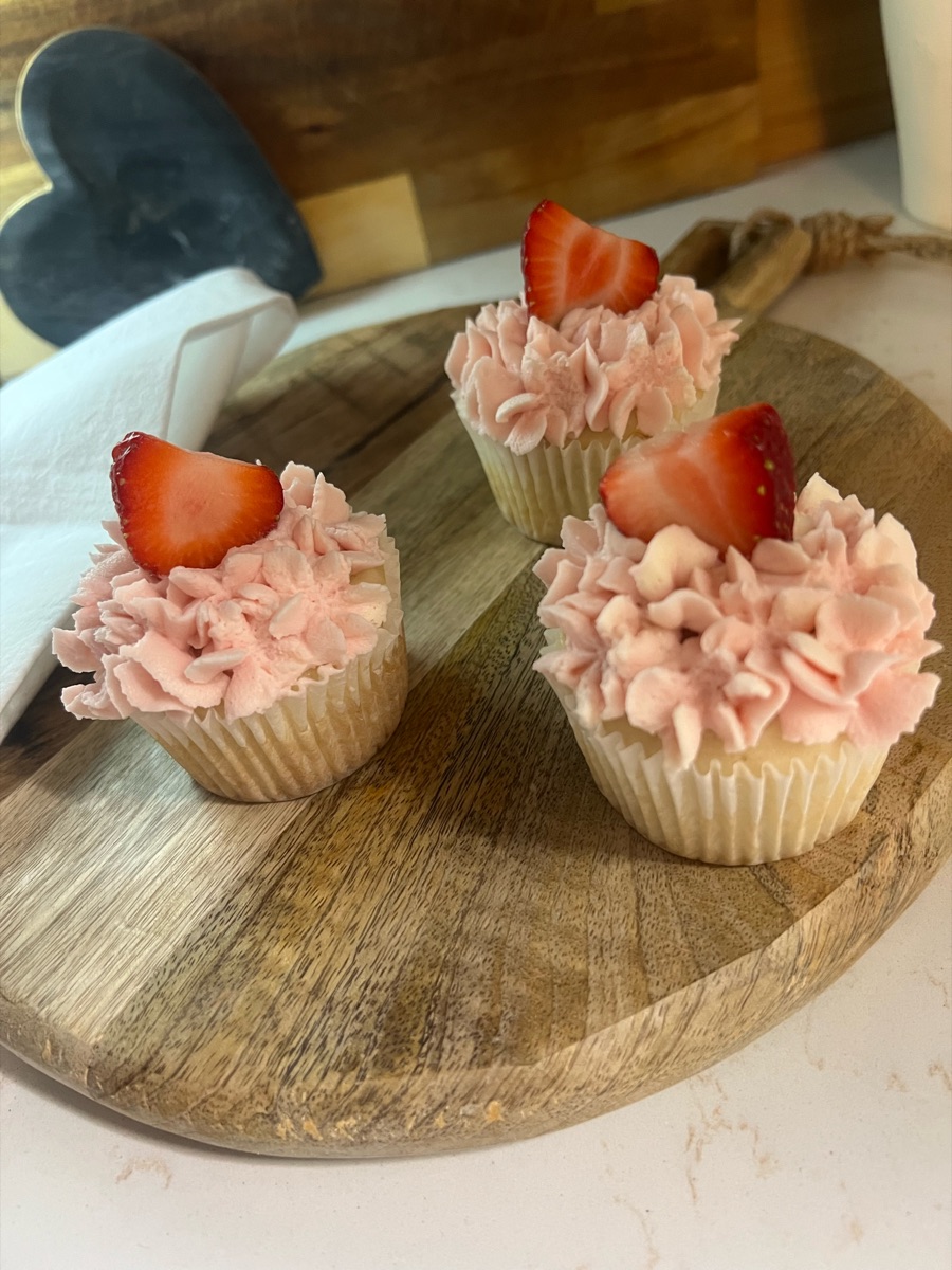 Vanilla cupcakes with pink ruffled buttercream and fresh strawberry slices
